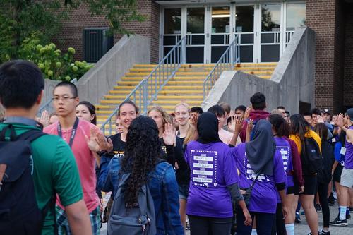 Students line up for high-fives outside the Physical Activities Complex.