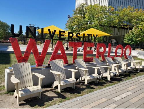 The University of Waterloo sign in the Arts Quad wrapped in red.