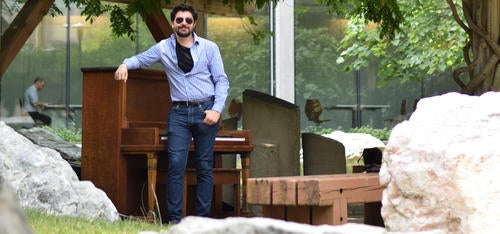 PhD candidate Max Salman with one of the public pianos in the Peter Russell Rock Garden.