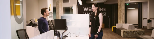 A woman stands at the counter at The Centre and interacts with a staff member.