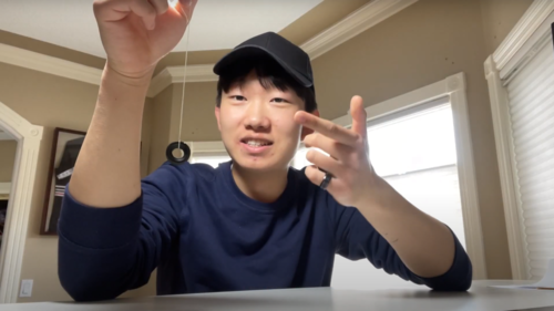 Jonathan Zhou holds a magnet on a string.