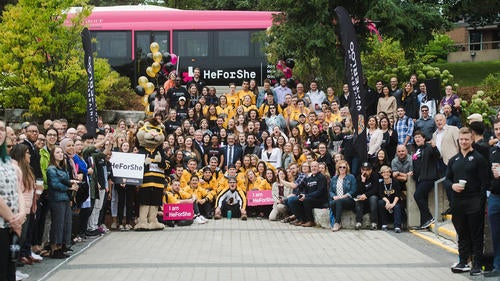 The Waterloo community gathers on the stairs in front of the HeForShe tour bus