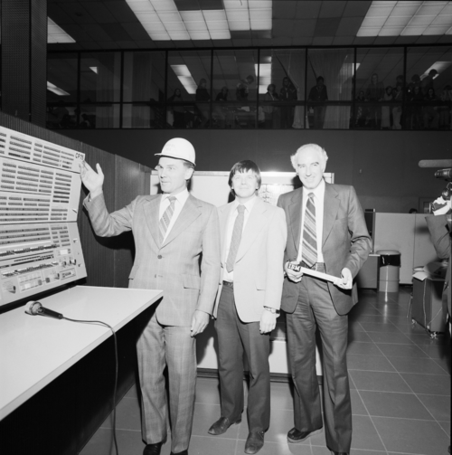 Black and white photo of Burt Matthews, Paul Dirksen and Wes Graham standing beside a large computer console in the Red Room.