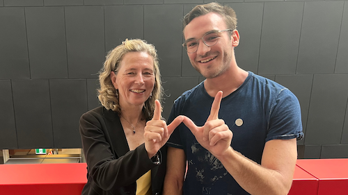 Dean of Engineering Mary Wells and fourth-year Electrical Engineering student Duke Gand make a &quot;W&quot; sign with their hands as they sport the new Engineering pin. 