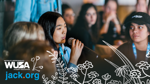 Students take turns speaking into a microphone while seated at tables.