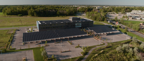 An aerial view of a large building with solar panels on the R+T Park campus.