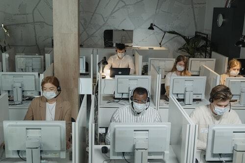People wear masks working in a call centre.