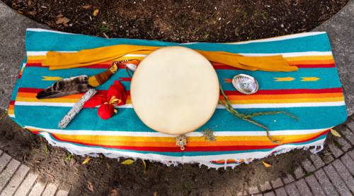 Indigenous ceremonial items arrayed on a blanket.