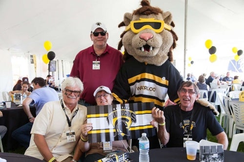 King Warrior poses with alumni at a Reunion event.
