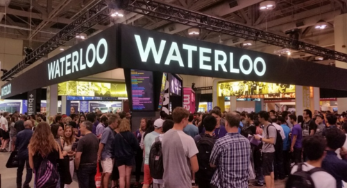 Crowds of prospective visitors outside the University of Waterloo booth on the convention floor.