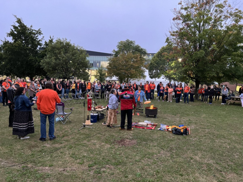 Jean Becker and Myeengun Henry conduct the sunrise ceremony with people looking on.