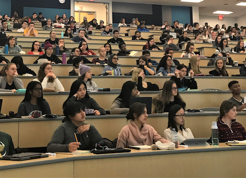 Students seated in a traditional lecture hall.