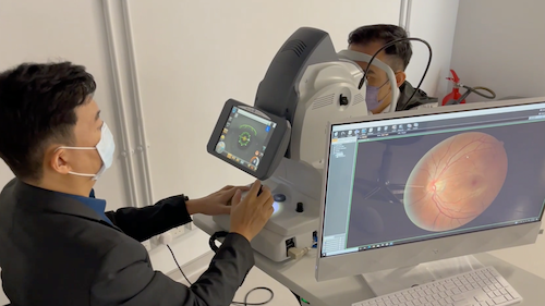 A researcher scans a patient's eye with a high-tech scanning device.