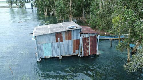 An amphibious home made of corrugated metal sheeting.