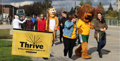 A Thrive Week march that includes people wearing mascot costumes.