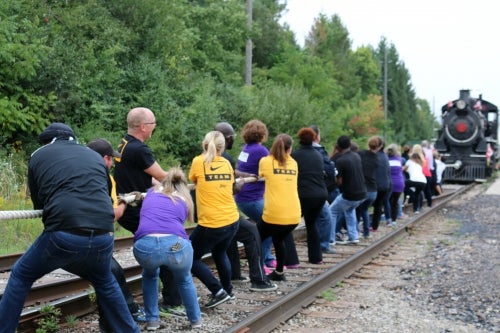 Volunteers pull a train.