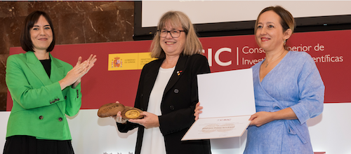 Dr. Donna Strickland receives her gold medal and CSIC citation as two representatives look on.