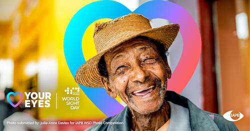 An elderly man smiles on the World Sight Day banner