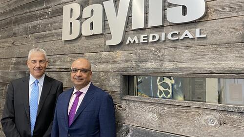 Business partners Frank Baylis, left, and Kris Shah in front of a Baylis Medical sign.