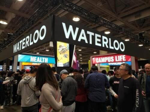 The crowd surges around the University of Waterloo booth at the 2024 Ontario Universities Fair.