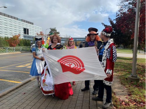 The six Deans in costume holding the United way flag.