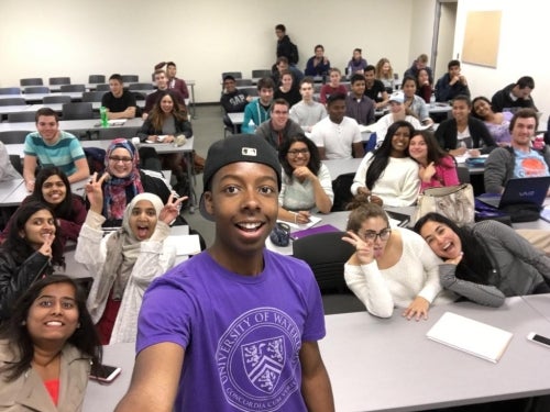 Jordan Grant takes a selfie with his classmates in the background.