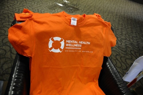 A basket of orange Mental Health Wellness Day shirts.