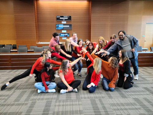 The team in Marketing and Undergraduate Recruitment wearing red putting their hands together.