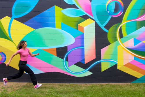 Artist Stephanie Boutari runs past a mural that she created.