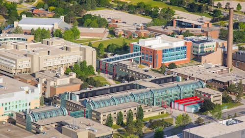 An aerial photo of the University of Waterloo's main campus with mathematics buildings in the centre.