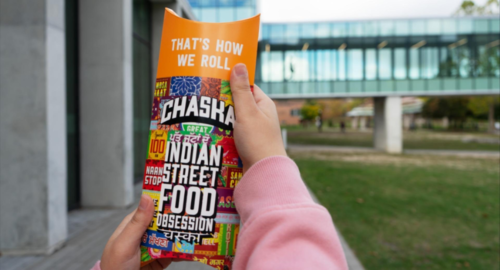 A person holds up a Chaska wrap container.