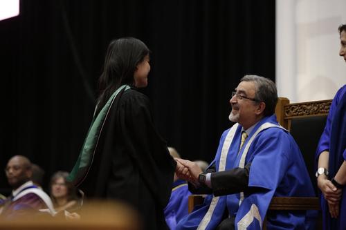 President Feridun Hamdullahpur congratulates a graduating student on the stage at Convocation.