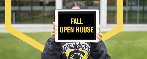 A student holds up a tablet that says &quot;Fall Open House.&quot;