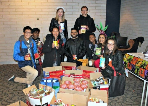 Volunteers pose with food collected during Trick or Eat 2015.