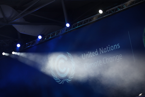 A stage setup with the words United Nations Climate Change on a wall banner.