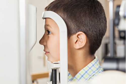 A young boy takes an eye exam with a special headset.