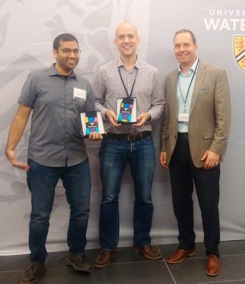  Jay Shah, Director of Velocity, Tomas VanStee, President of EnPowered, and Jason Coolman, Associate Vice-President, Development, Office of Advancement pose with socks.