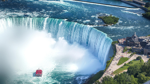 An overhead view of Niagara Falls with the Hornblower tourist boat nearing the falls.