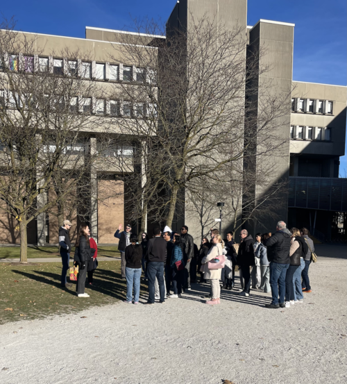 A campus tour stops in front of the Mathematics &amp; Computer building.