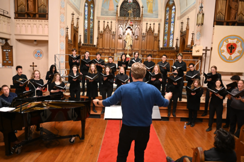 Mark Vuorinen conducts the chamber choir in a church.