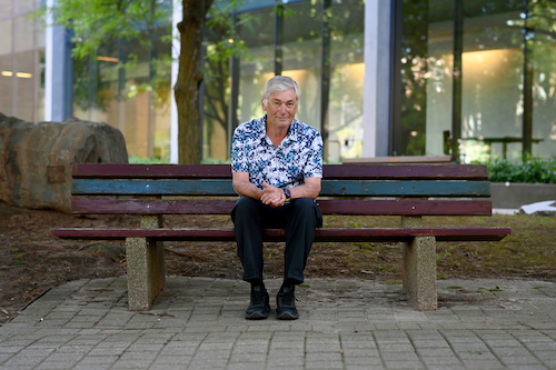 Professor J. Ian Munro sits in the Peter Russell Rock Garden.