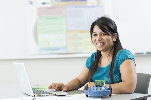 A female student works at a laptop.