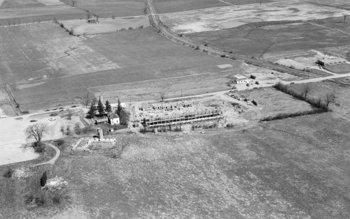  aerial view of Schweitzer Farmhouse (now Grad House) and Chemical Engineering foundations. 1958.