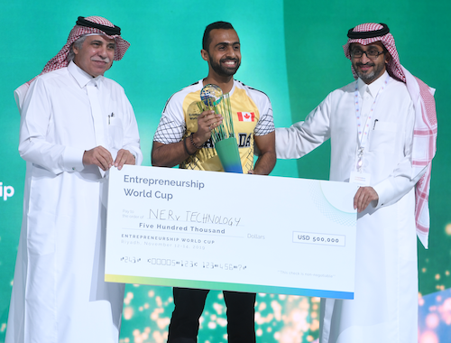 A representative of NERv Technologies with two Saudi businessmen and an oversized cheque.