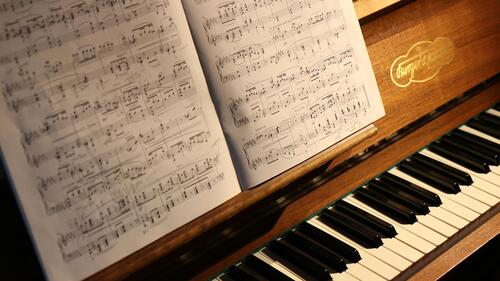 close-up photo of a piano keyboard and sheet music.