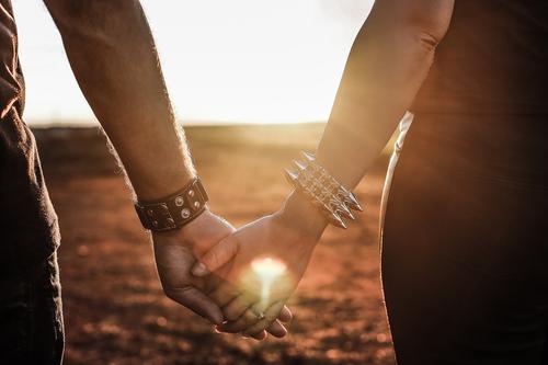 A couple holds hands during sunset