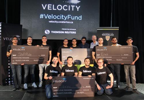 Winners in the $25,000 category at the Velocity Fund Finals pose on stage with their ceremonial cheques.