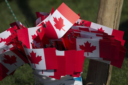 A cluster of small Canadian flags wave in the breeze