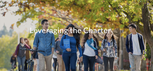 Students walk along a tree-lined pathway with the words &quot;leveraging the charter&quot; over top.