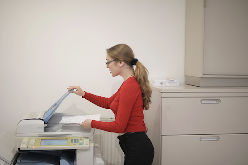 A woman photocopies a document.